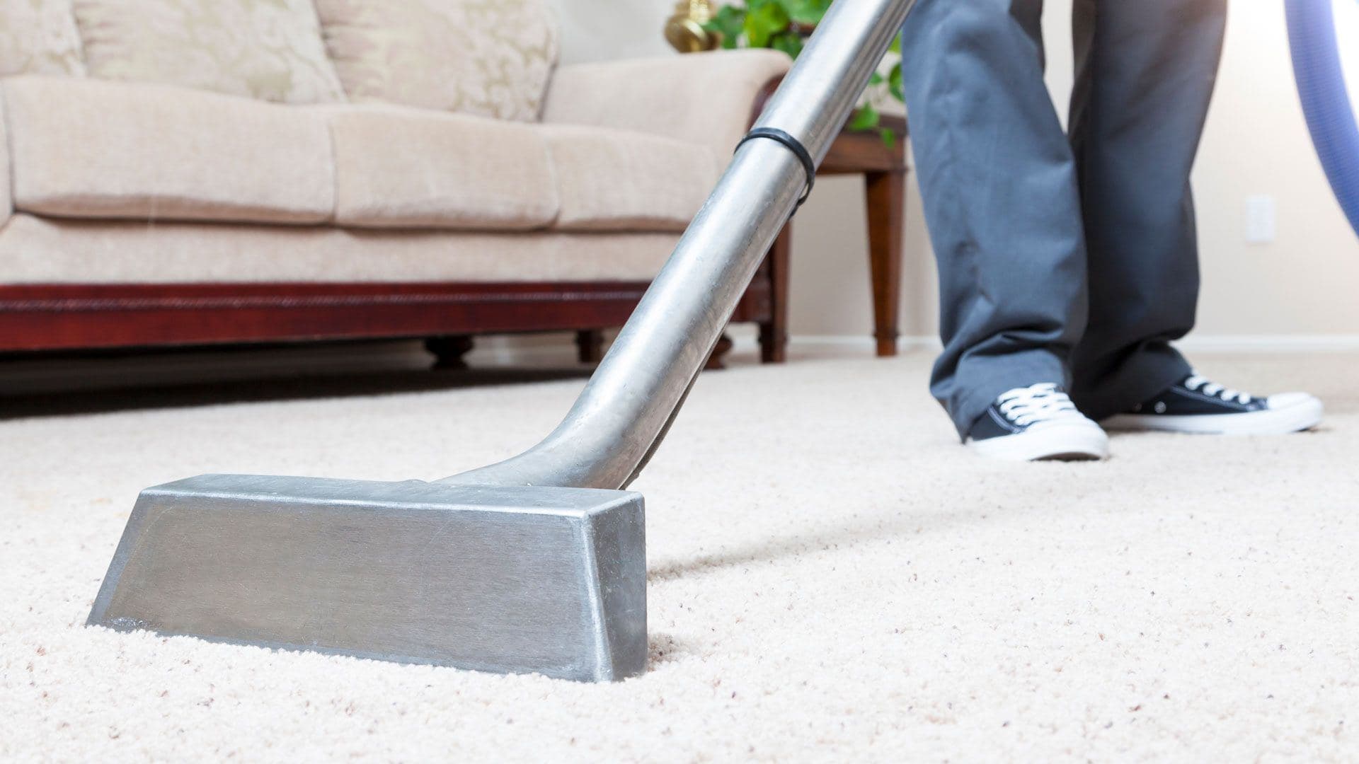 Carpet cleaning wand extracting dirt from a beige carpet